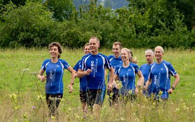 Mitglieder des SSC Sihltaler Sportclubs laufen in Adliswil 8134 im Kanton Zurich gemeinsam durch eine naturnahe Wiesenlandschaft waehrend eines Lauftrainings.