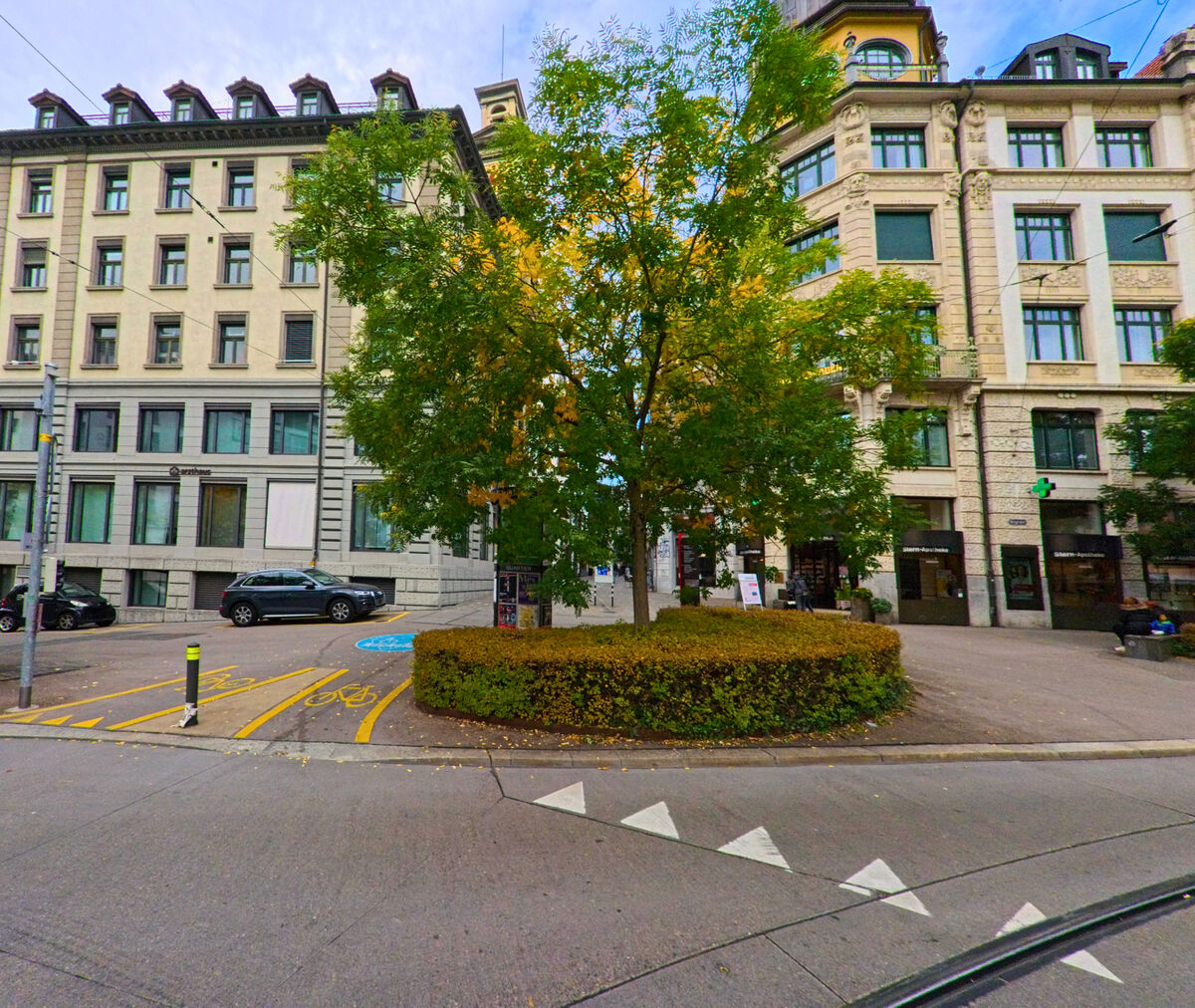 Begruenung in der Verkehrsmitte strukturiert einen Knotenpunkt zwischen Gebaeuden in St. Gallen (9001, Kanton St. Gallen).