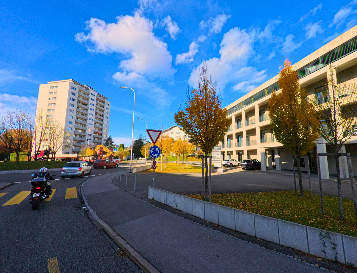 Ein Kreisverkehr mit angrenzenden Wohn- und Geschaeftsgebaeuden liegt im Ortsgebiet von St. Margrethen (9430, Kanton St. Gallen).