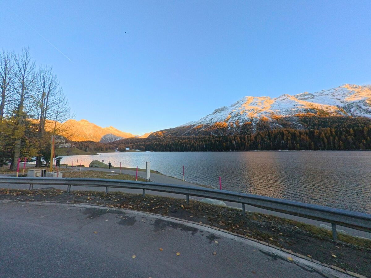 Am Ufer des Sees öffnet sich in St. Moritz (7500, Kanton Graubünden) der Blick auf ruhiges Wasser und schneebedeckte Berge im warmen Abendlicht.
