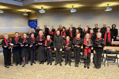 Der Stadtchor steht mit geöffneten Notenmappen in einem Kirchenraum in Dübendorf (8600, Kanton Zürich) für ein gemeinsames Gruppenbild bereit.