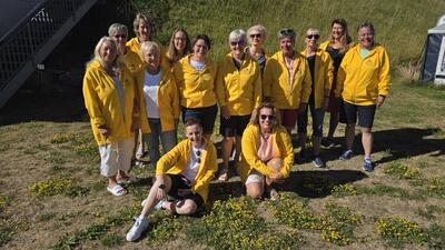 Die Mitglieder der Steelband Lipsticks posieren in gelben Vereinsjacken für ein gemeinsames Gruppenfoto im Freien in Wohlen (5610, Kanton Aargau).