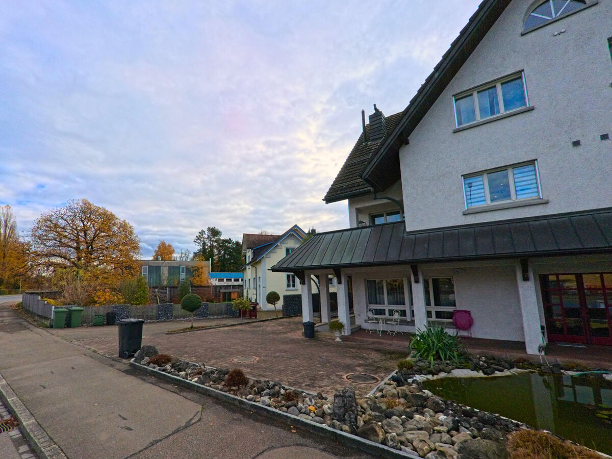 Ein Vorplatz mit Sitzgelegenheiten liegt vor einem Wohngebaeude in Steinach (9323, Kanton St. Gallen).