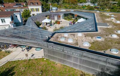 Ein modernes Gebaeude mit Innenhof und Beschriftung liegt in Basel (4052, Kanton Basel Stadt) und zeigt ein Tierheim mit grosszuegiger Anlage.