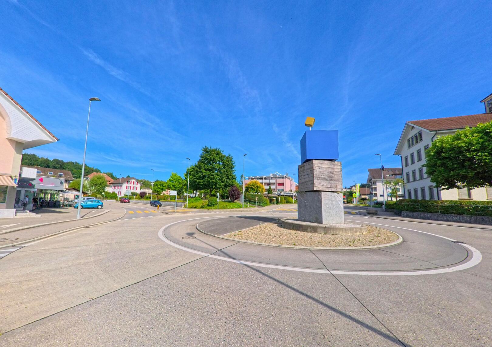 Im Zentrum von Strengelbach (4802, Kanton Aargau) befindet sich ein moderner Kreisverkehr mit einer kuenstlerischen Skulptur aus verschiedenen geometrischen Formen.