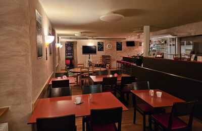 Im Sunne Beizli in Neunkirch (8213, Kanton Schaffhausen) laden warme Beleuchtung, rote Tische und eine gemuetliche Bar mit Dartautomat zum Verweilen ein.