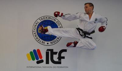 In Rueti (8630, Kanton Zuerich) zeigt ein Mitglied der Taekwon-Do Schule Rueti einen kraftvollen Sprungkick vor dem Logo der International Taekwon-Do Federation.