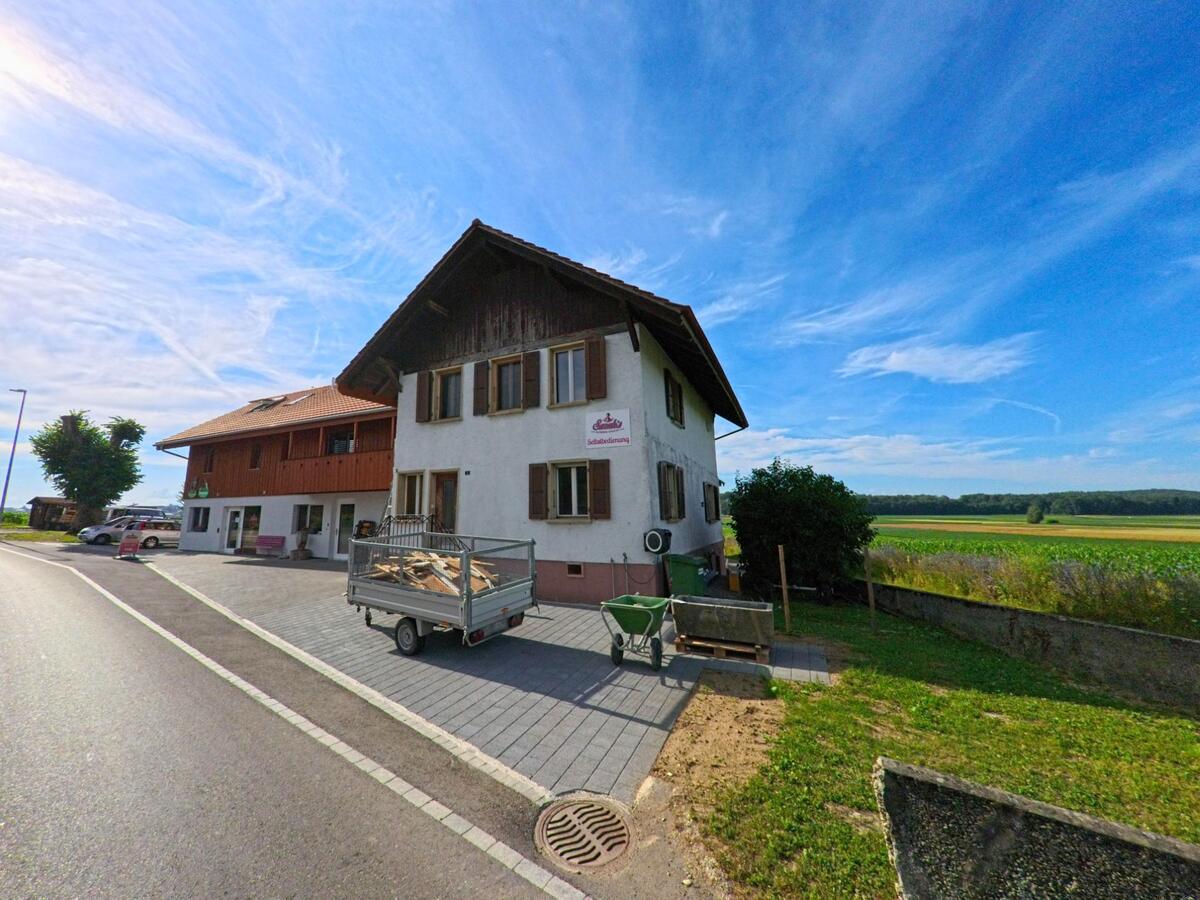 Am Dorfrand von Täuffelen (2575, Kanton Bern) steht ein traditionelles Gebäude mit Selbstbedienungsladen direkt an der Landstrasse und mit Blick auf die Felder.