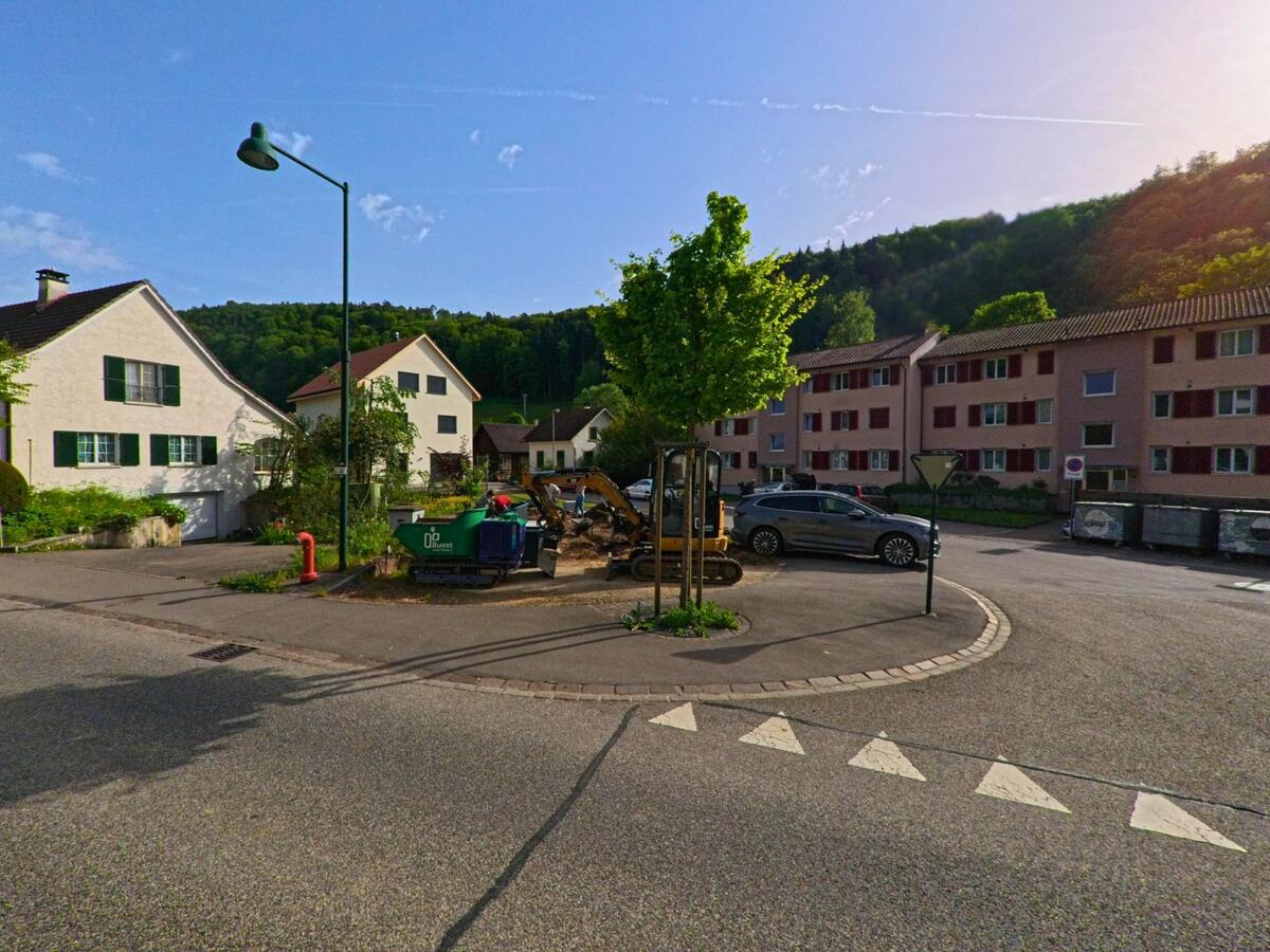 In Tecknau (4492, Kanton Basel-Landschaft) wird an einer kleinen Strasseninsel inmitten eines Wohngebiets mit Ein- und Mehrfamilienhäusern gebaut.