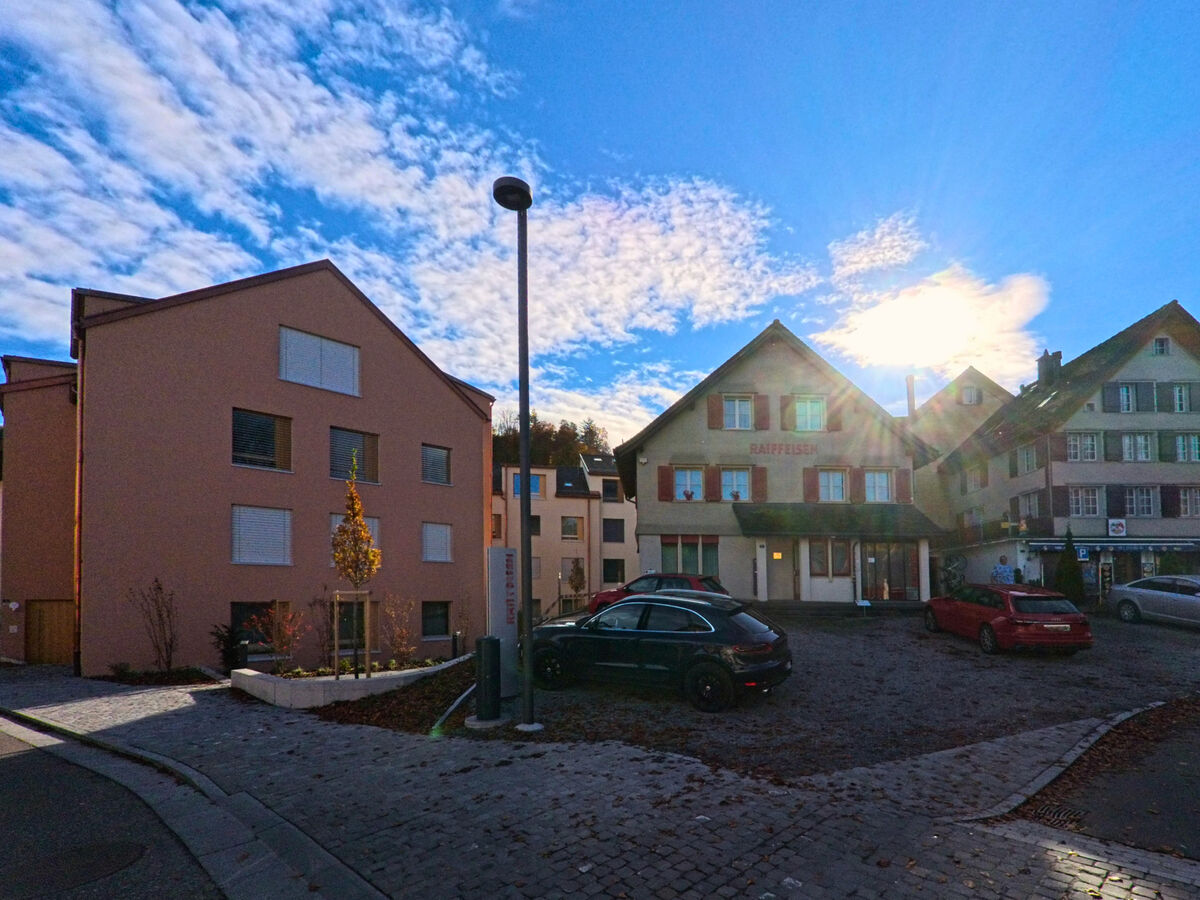 Ein kleiner Platz mit Parkflaechen befindet sich zwischen Wohnbauten in Thal (9425, Kanton St. Gallen).