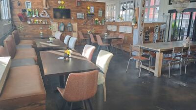 In Oberentfelden (5036, Kanton Aargau) bietet The Coffee Factory einen modern eingerichteten Innenraum mit Holzwanddekor, unterschiedlichen Sitzbereichen und kleinen Blumendekorationen auf den Tischen.