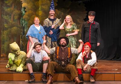 Mitglieder des Theater Escholzmatt stehen in fantasievollen Kostümen gemeinsam auf einer Bühne vor einer Waldkulisse. Das Gruppenbild zeigt eine Theaterproduktion in Escholzmatt-Marbach (6182, Kanton Luzern).
