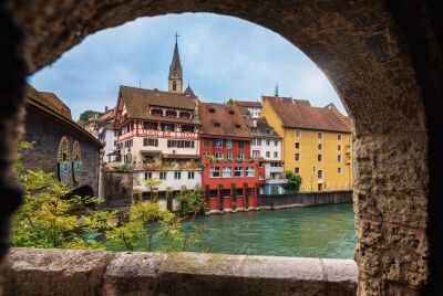 Durch einen steinernen Torbogen fällt der Blick auf die farbenfrohen Häuser an der Limmat in Baden (5400, Kanton Aargau).