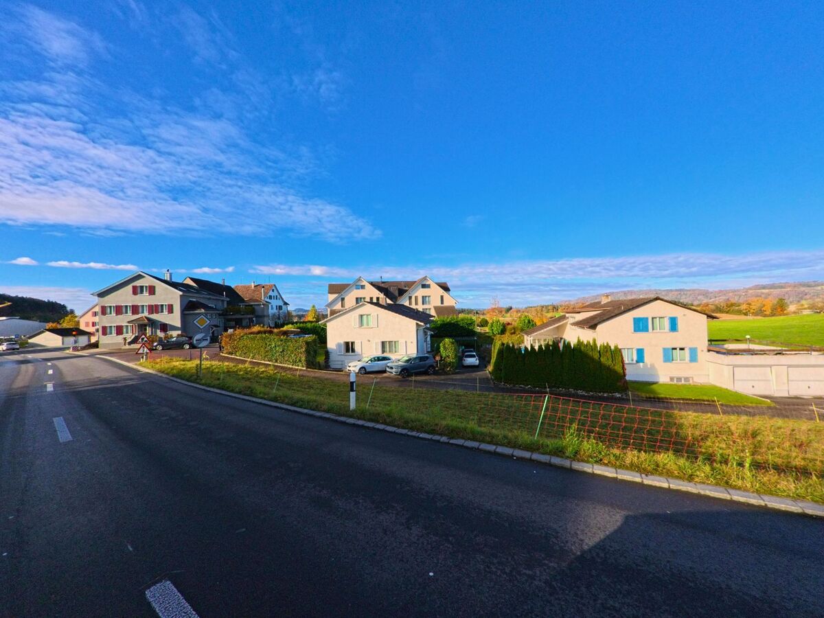 Mehrere Einfamilienhaeuser mit Gärten liegen entlang einer Strasse in Tobel-Taegerschen (9555, Kanton Thurgau) mit freiem Blick auf die umliegende Landschaft.