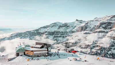 Auf dem verschneiten Gipfel bei den Torrent-Bahnen Leukerbad-Albinen AG in Leukerbad (3954, Kanton Wallis) geniessen Skifahrer unter blauem Himmel die Aussicht auf die umliegenden Alpen.