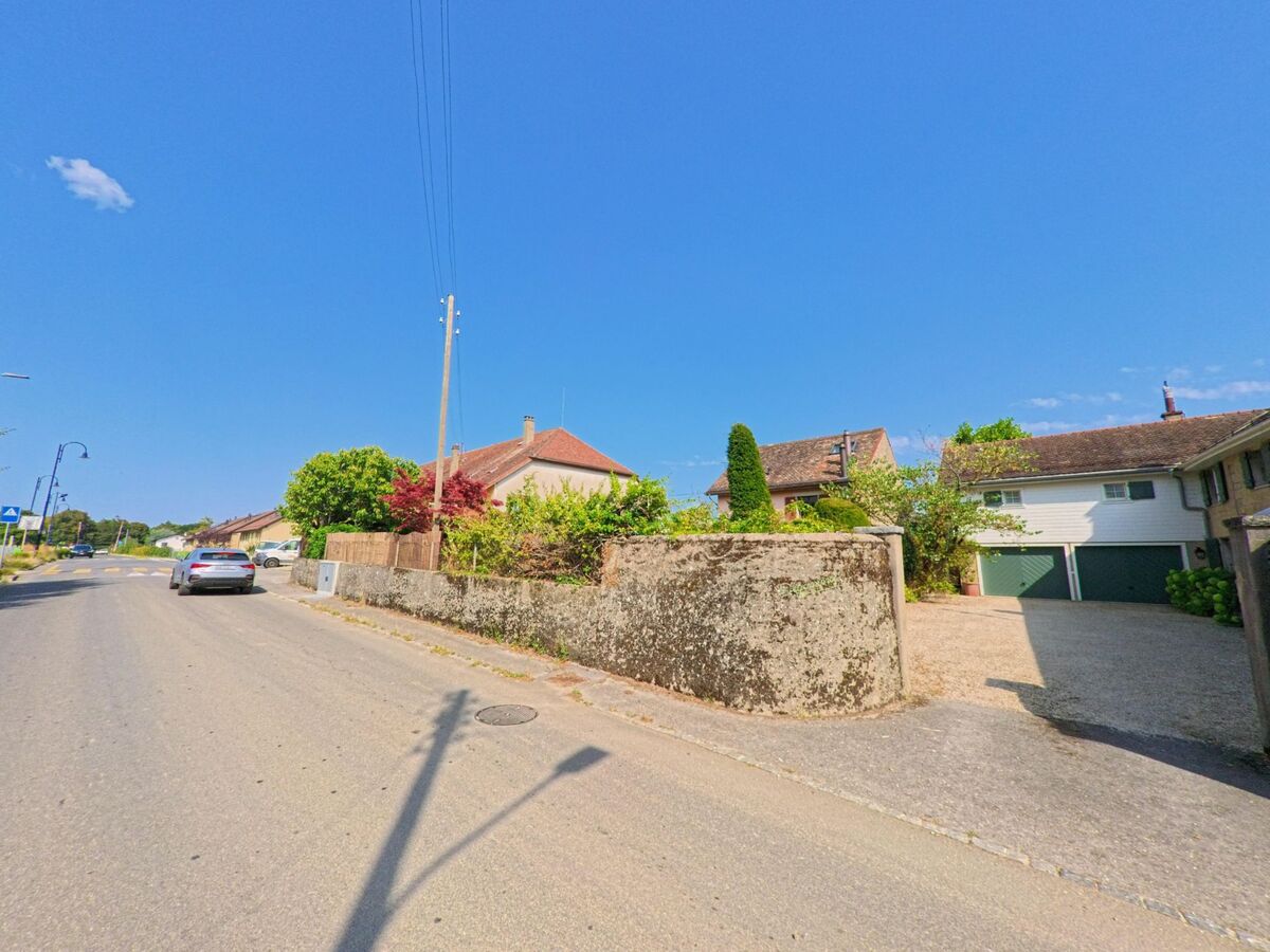 In Trelex (1270, Kanton Waadt) befindet sich ein Wohnquartier mit Garagenzufahrt hinter einer Steinmauer, wo ein Kammerjaeger im Einsatz ist.