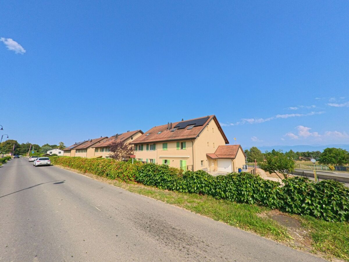 Reihenhaeuser mit gruener Fensterlaeden und bepflanzter Hecke in Trelex (1270, Kanton Waadt), wo ein Kammerjaeger eine Kontrolle im Wohngebiet durchfuehrt.