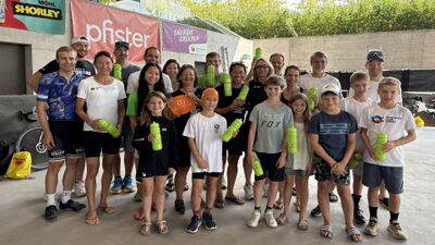 In Aarau (5000, Kanton Aargau) posiert eine grosse Gruppe des Triathlon Club Aarau mit Kindern und Erwachsenen fuer ein gemeinsames Foto und haelt gruene Trinkflaschen in den Haenden.