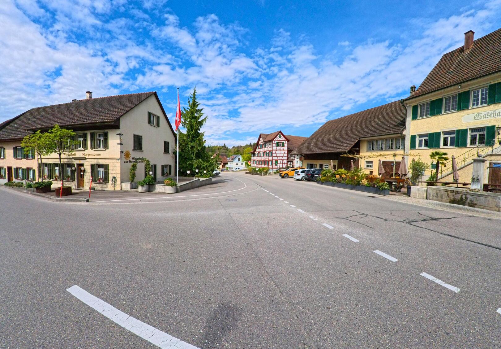 Im Zentrum von Truellikon (8466, Kanton Zuerich) fuehrt die Hauptstrasse an traditionellen Gasthaeusern und einem Fachwerkhaus vorbei.