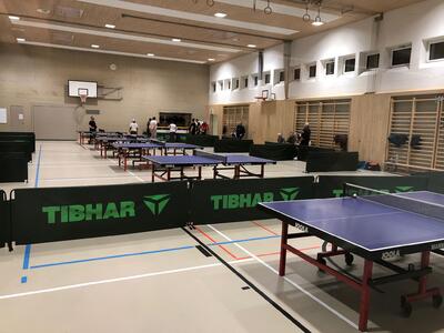 In einer Sporthalle in Spreitenbach (8957, Kanton Aargau) stehen mehrere Tischtennistische des TTC Spreitenbach für Training und Wettkämpfe bereit.