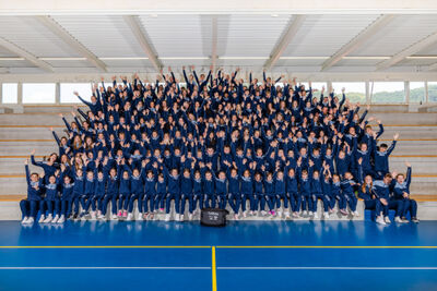 In einer Sporthalle in Dagmersellen (6252, Kanton Luzern) sitzt der Nachwuchs des Turnverein Dagmersellen Aktive in mehreren Reihen auf Treppenstufen fuers offizielle Gruppenfoto.