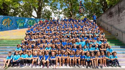 Der Turnverein Obfelden versammelt sich in Obfelden (8912, Kanton Zürich) auf farbig bemalten Treppenstufen zu einem grossen Gruppenfoto im Freien.