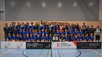 In Rafz (8197, Kanton Zuerich) posiert eine grosse Mannschaft des UHC Phantoms Rafzerfeld in einer Sporthalle fuer ein gemeinsames Teamfoto in blauen Trikots.