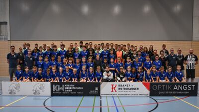 In Rafz (8197, Kanton Zuerich) posiert eine grosse Mannschaft des UHC Phantoms Rafzerfeld in einer Sporthalle fuer ein gemeinsames Teamfoto in blauen Trikots.