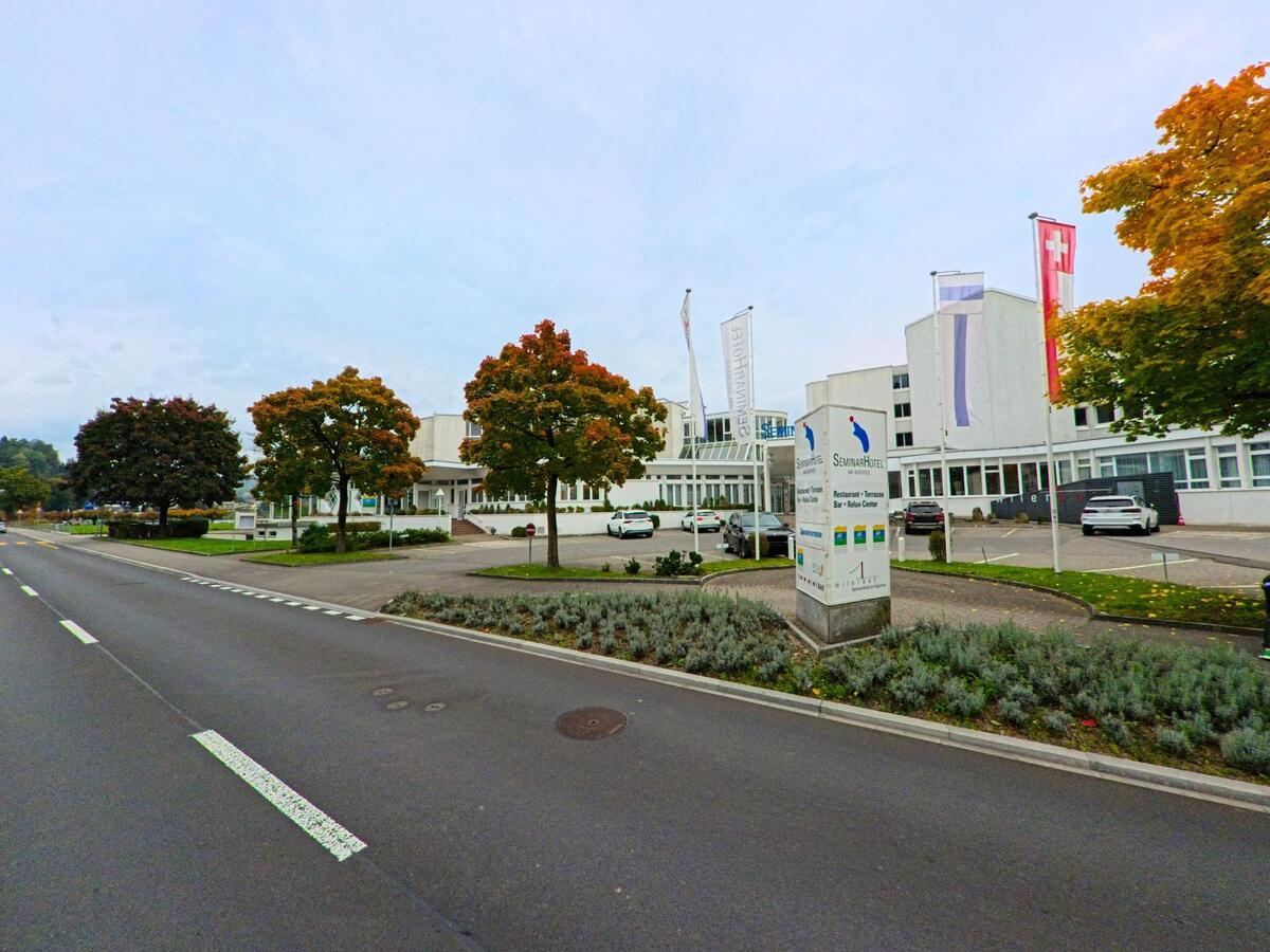 Ein moderner Weissbau liegt an einer breiten Strasse im Siedlungsbereich von Unterägeri (6314, Kanton Zug).