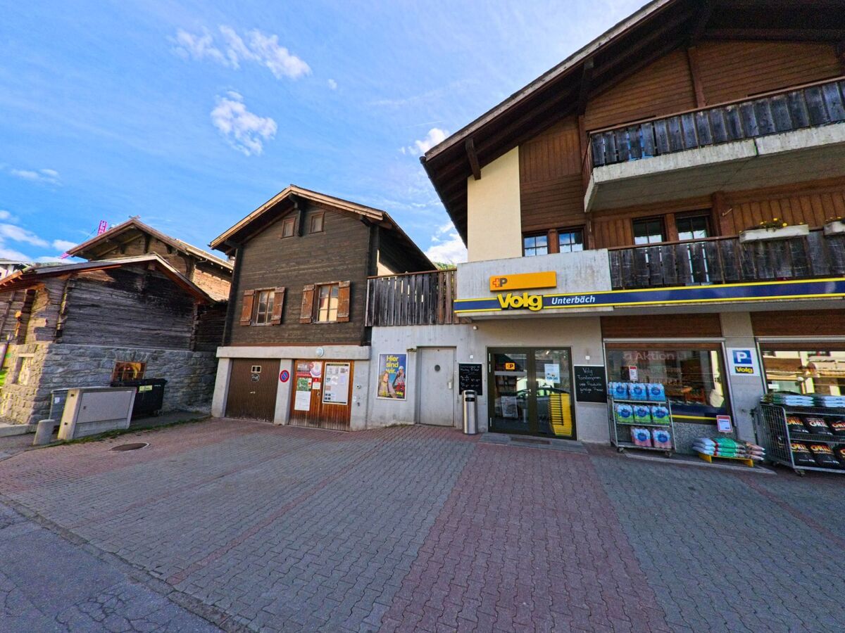 Im Zentrum von Unterbaech (3944, Kanton Wallis) befindet sich ein Volg-Laden in einem traditionellen Gebaeude mit Holzverkleidung.