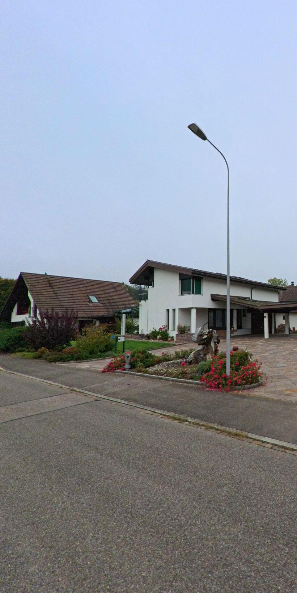 Ein modernes Wohnhaus mit gepflegtem Vorgarten steht in Unterentfelden (5035, Kanton Aargau) an einer ruhigen Strasse mit breitem Trottoir.