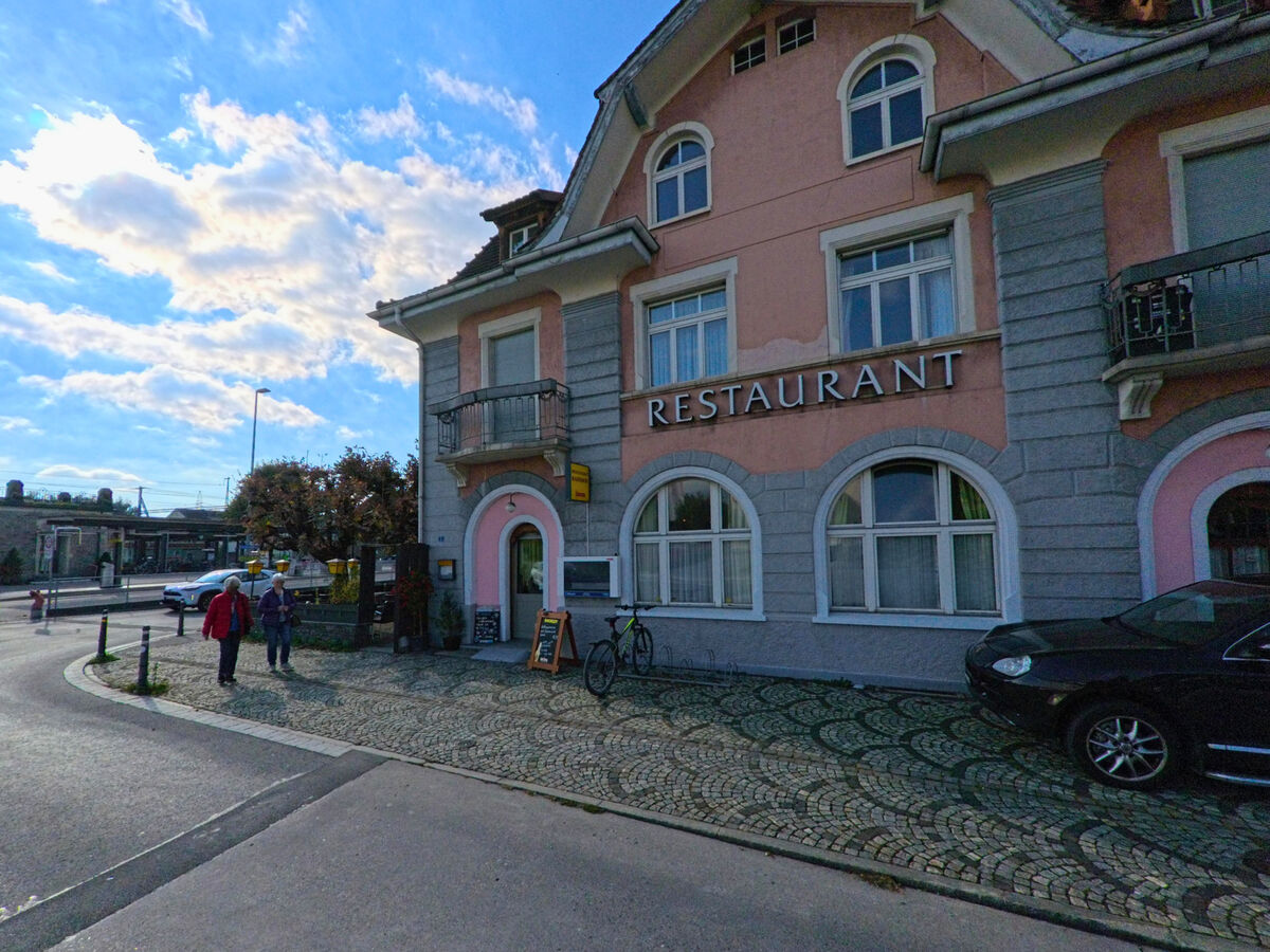 Ein Gastronomiegebaeude mit Beschriftung steht an einer belebten Strasse in Uznach (8730, Kanton St. Gallen).