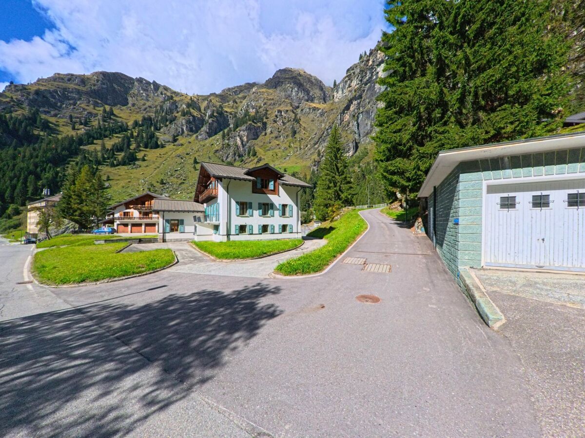 Eine kurvige Quartierstrasse fuehrt an Wohnhaeusern vorbei durch eine alpine Siedlung in Val de Bagnes (1934, Kanton Wallis).
