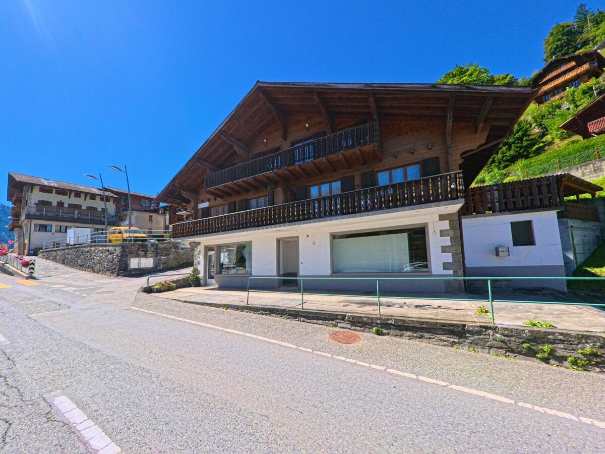 Ein traditionelles Chalet mit dunklen Holzbalkonen steht an der Hauptstrasse von Val-d'Illiez (1873, Kanton Wallis).