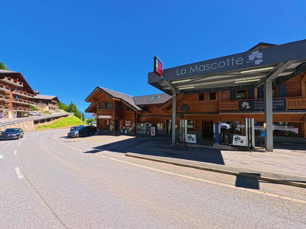 Eine kleine Tankstelle mit Laden in Val-d'Illiez (1873, Kanton Wallis) befindet sich direkt an der Strasse, umgeben von Chalets und Wohnhäusern.