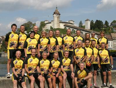 Vor einer historischen Festungsanlage posiert in Schaffhausen (8200, Kanton Schaffhausen) eine Gruppe von Radfahrern in gelben Trikots gemeinsam zu einem Gruppenfoto.
