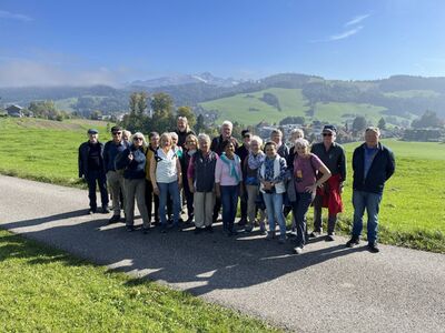 Mitglieder des Vereins 60 plus Andwil-Arnegg aus Andwil (9204, Kanton St. Gallen) posieren während einer Wanderung auf dem Wolfensberg vor einer malerischen Bergkulisse.