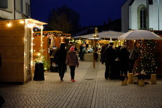 Stimmungsvoller Adventsmarkt des Verein Advent in Pfäffikon in Pfäffikon (8330, Kanton Zürich). Besucher schlendern am Abend zwischen festlich beleuchteten Marktständen und Weihnachtsdekorationen auf einem Dorfplatz. Die Veranstaltung schafft eine gemütliche vorweihnachtliche Atmosphäre für die Bevölkerung der Gemeinde.