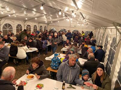 Im Festzelt des Verein Birreter Weihnachtsmarkt in Birrhard, PLZ 5244, Kanton Aargau, sitzen zahlreiche Besucherinnen und Besucher an langen Tischen zusammen.