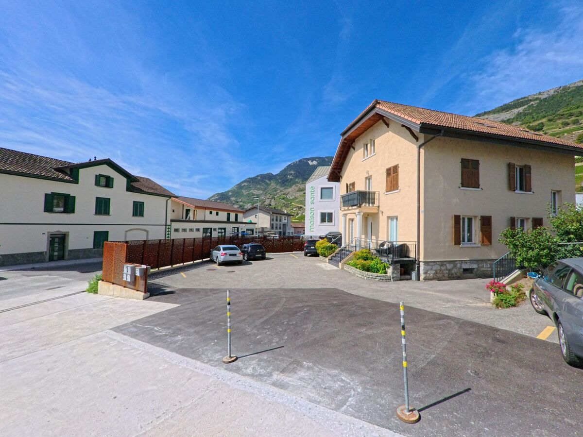 Im Zentrum von Vetroz (1963, Kanton Wallis) stehen traditionelle Wohnhaeuser mit Parkplaetzen vor den umliegenden Weinbergen.