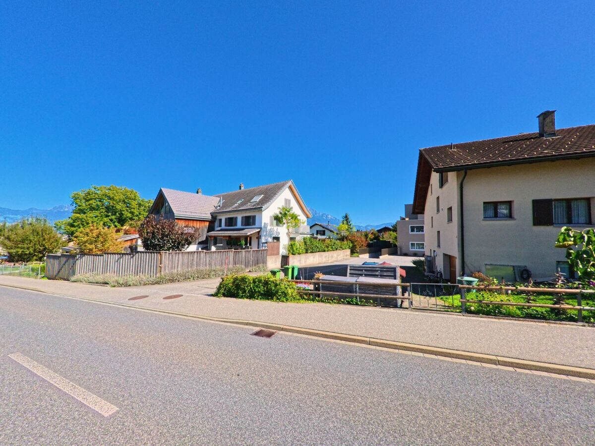 Mehrere Einfamilienhaeuser mit gepflegten Gaerten reihen sich in Vilters-Wangs (7324, Kanton St. Gallen) entlang einer ruhigen Strasse mit Blick auf die Berge.
