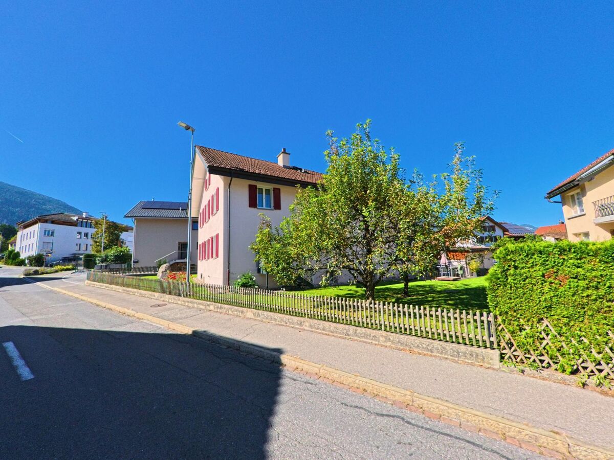 Ein Wohnhaus mit roten Fensterlaeden und gepflegtem Garten steht in Vilters-Wangs (7324, Kanton St. Gallen) an einer sonnigen Nebenstrasse.