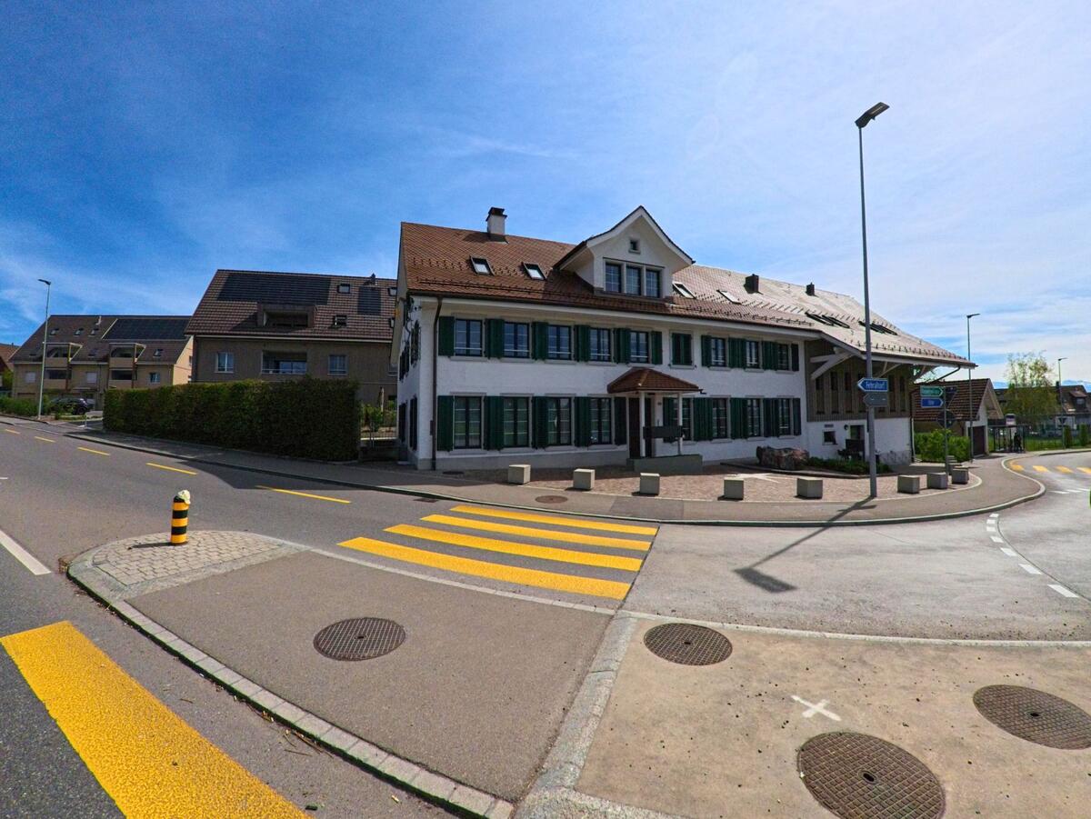In Volketswil (8605 im Kanton Zürich) befindet sich das Restaurant Sternen an einer gut ausgebauten Strassenkreuzung mit mehreren Zebrastreifen und Wohnhäusern im Hintergrund.