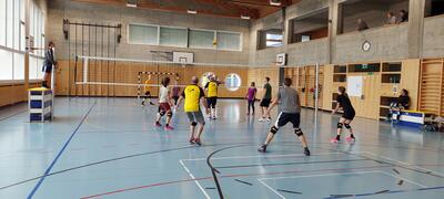 In der Sporthalle von Schwarzenbach SG (9536, Kanton St. Gallen) spielen Mitglieder von Volley Joschwa ein Volleyballmatch unter einer hohen Holzdecke.