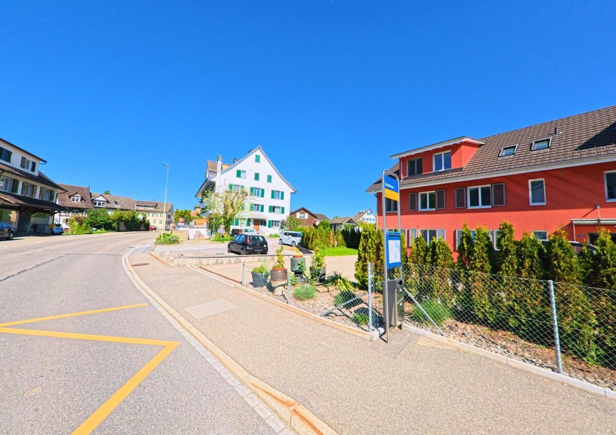 In Wädenswil (8825 im Kanton Zürich) liegt an einer ruhigen Wohnstrasse eine Bushaltestelle zwischen modernen und traditionellen Wohnhäusern.