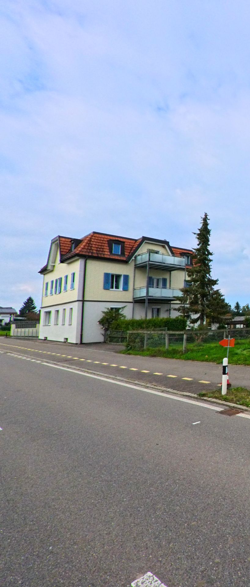 An einer ruhigen Strasse in Waldkirch (9205, Kanton St. Gallen) steht ein Mehrfamilienhaus mit Balkonen, Vorgarten und angrenzender Gruenflaeche.