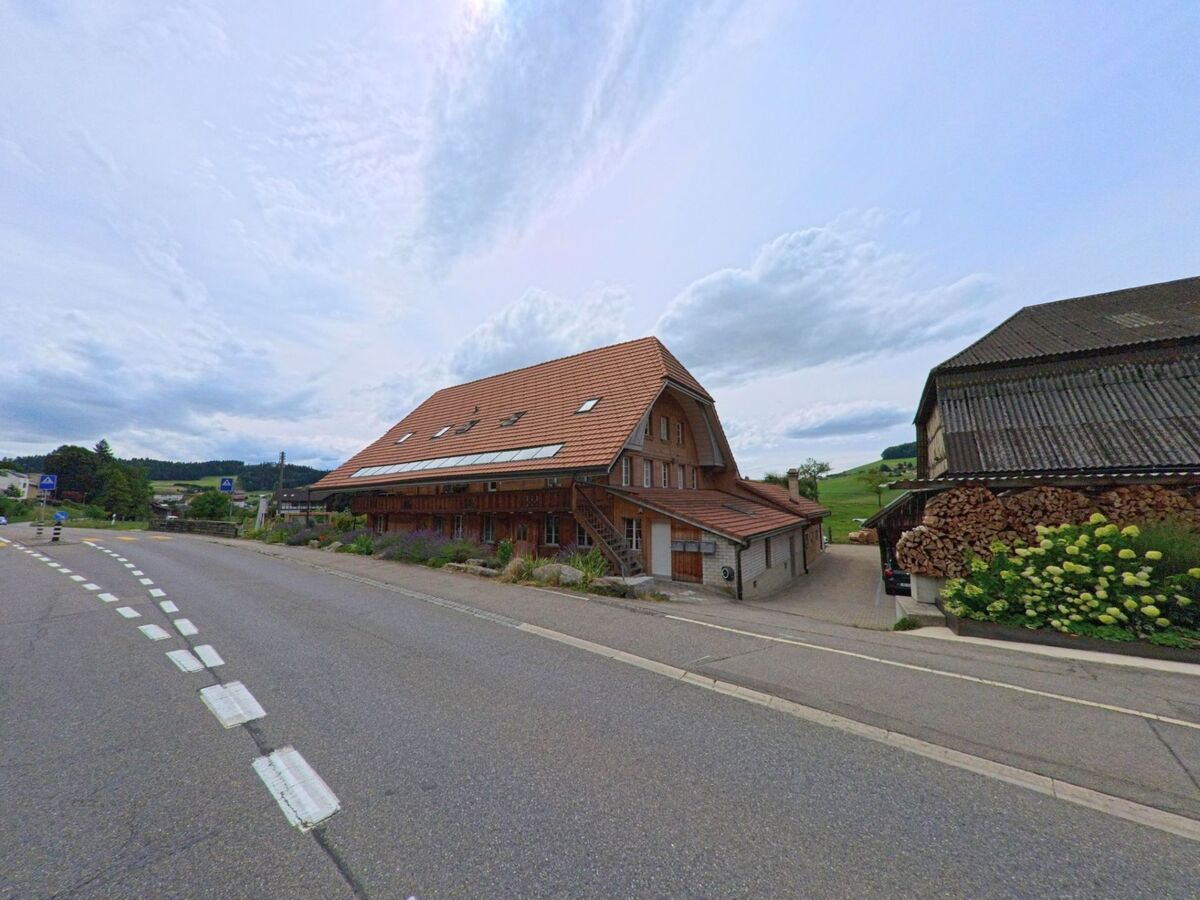 Ein traditionelles Bauernhaus mit steilem Satteldach steht in Walkringen (3512, Kanton Bern) direkt an einer verkehrsberuhigten Landstrasse.