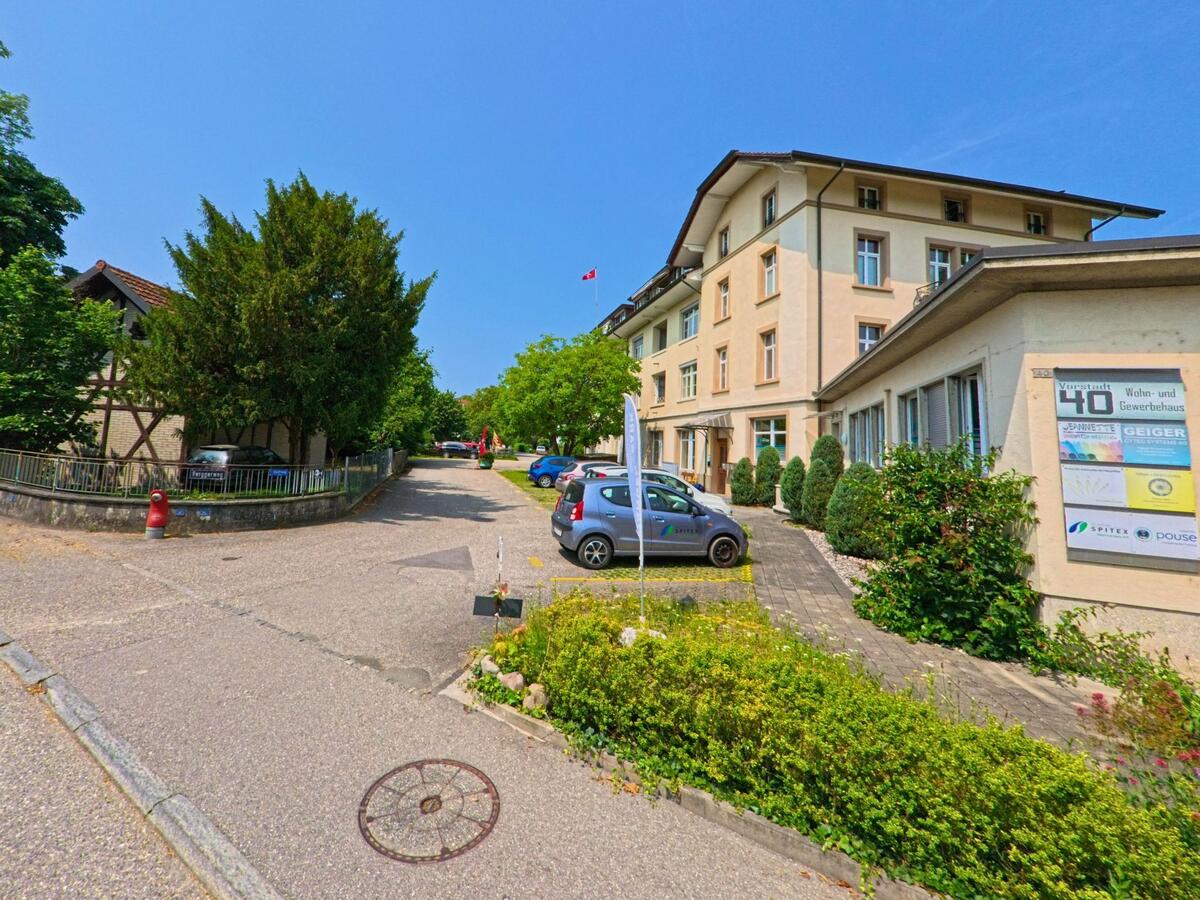 In Wangen an der Aare (3380, Kanton Bern) steht das Wohn- und Gewerbehaus an der Vorstadt 40 neben einem Fachwerkhaus und einem begrünten Vorplatz.