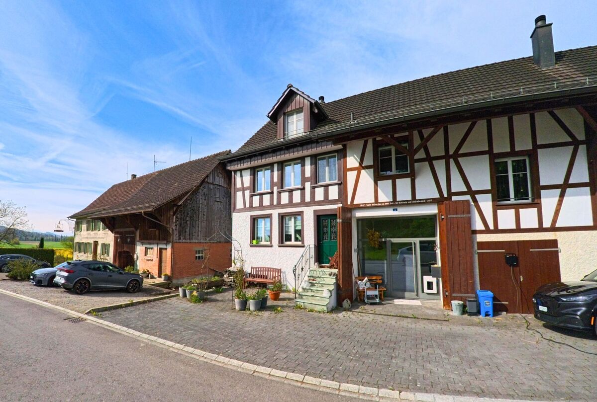 In Wasterkingen (PLZ 8195, Kanton Zürich) reihen sich an einer ruhigen Strasse zwei Bauernhäuser mit Fachwerkfassade und Scheunenteil nebeneinander.