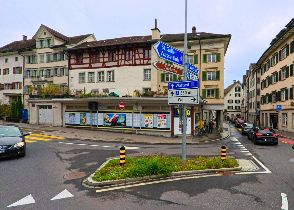 Ein Verkehrsknoten mit Wegweisern und Geschaeften befindet sich im Zentrum von Wattwil (9630, Kanton St. Gallen).